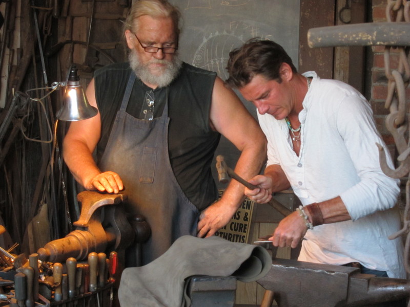 Under the watchful eye of Lewes Blacksmith John Ellsworth, Ty Pennington shapes spoons into apron hooks for Dale Dunning's new soup kitchen. BY DENNIS FORNEY