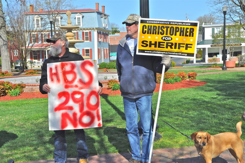 While others fill the Sussex County administration building, Michael Collins of Long Neck, left, and Rich Mutell of Laurel show their feelings concerning Sussex County Sheriff Jeff Christopher outside on The Circle in Georgetown. BY RON MACARTHUR