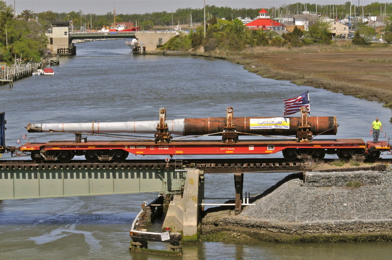 The 66-foot USS Missouri gun barrel rolls across the Lewes-Rehoboth Canal trestle bridge April 17 on the way to its new home at Fort Miles in Cape Henlopen State Park. BY RON MACARTHUR