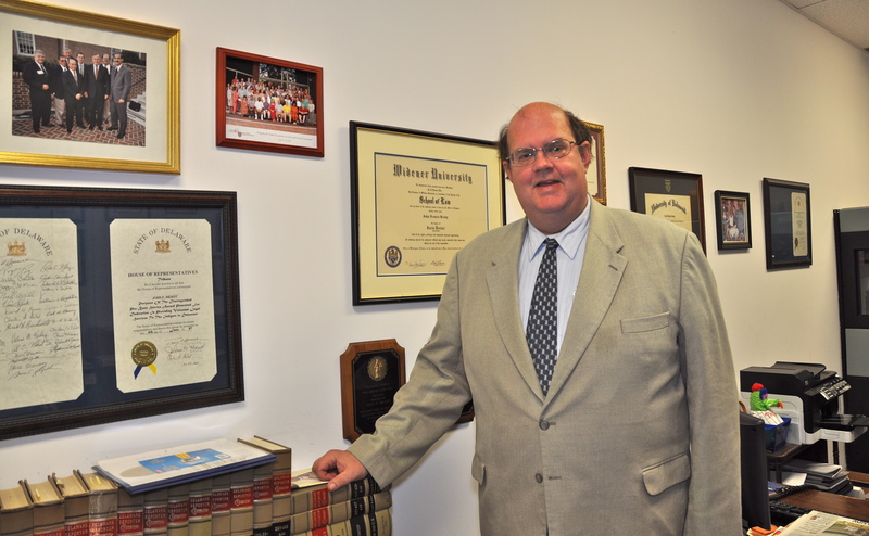 John Brady's law office walls are covered with plaques, certificates and photographs. BY RON MACARTHUR