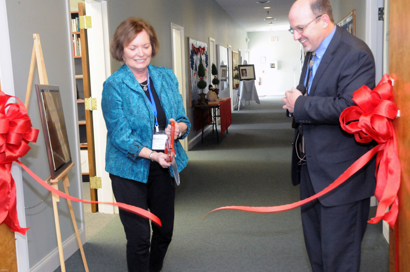 Sharon Vernon, wife of the late Bill Vernon, with encouragement from the Rev. Robert Dekker, cuts the ribbon on the new annex. The Bill Vernon Conference Room is the first door on the left. The wing of the church formerly stopped at the left side of the hall in the background. BY STEVEN BILLUPS