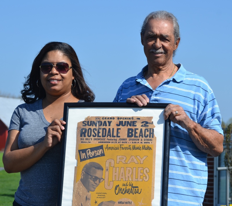 Delaware State University alumna Stephanie Collick, left, and Delaware State University Alumni Association Sussex County Chapter President Robert G. Draine show off an old Rosedale Beach concert poster procured from the artifact collection of Dara Laws-Savage. SOURCE SUBMITTED