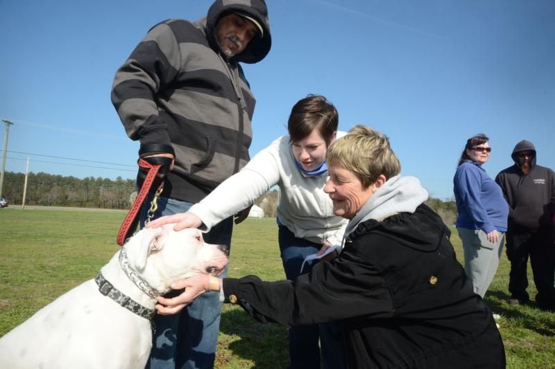 The Rev. Kelly Pensinger lays her hands on Jaz, as she gives him a blessing. Shown are (l-r) dog owner Luis Villarruel from New Jersey; Kelly; and Ellen Roe, Georgetown SPCA volunteer. BY STEVEN BILLUPS