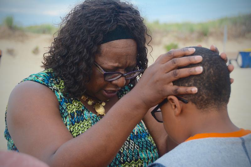 The Rev. Marjorie Burns prays for Daeveon DeShields, a Beacon Middle School sixth-grader. RON MACARTHUR PHOTO