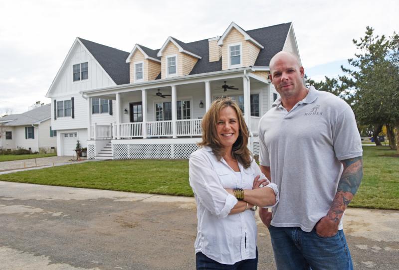 Stephanie Boright, left, and Justin Travis stand outside a Cedar Street home on which they recently completed a renovation. Though Boright now works full time as the owner of Coastal Cottage Renovations, she previously produced television and movies filmed in Washington, D.C. NICK ROTH PHOTO