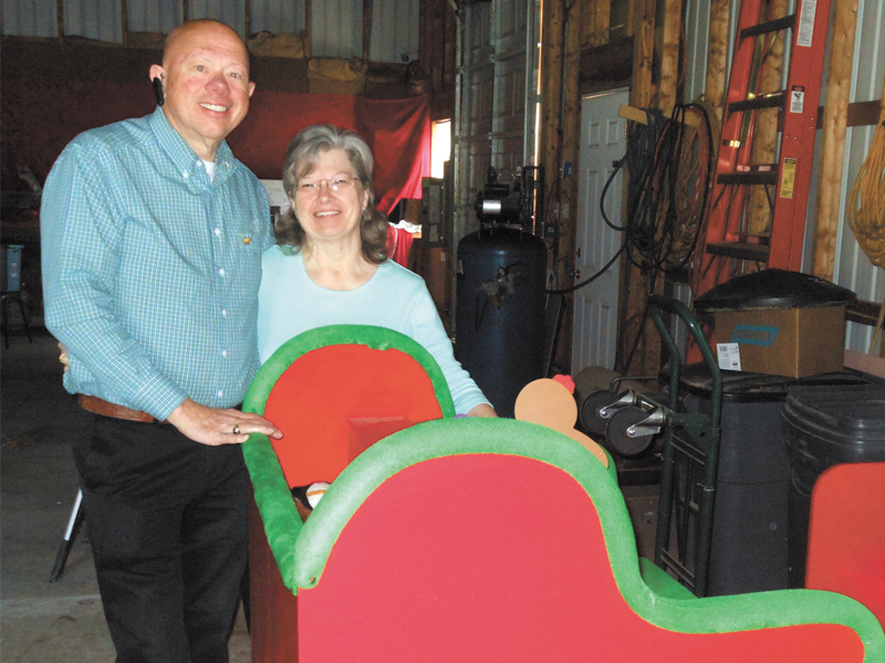 David and June Edwards stand next to the sleigh used by Santa when their Christmas village is open to the public. CHRIS FLOOD PHOTO