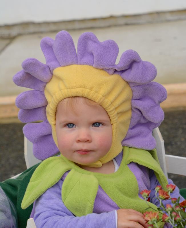 Savannah Care is cute as a flower bud as she rides in a wagon. RON MACARTHUR PHOTO