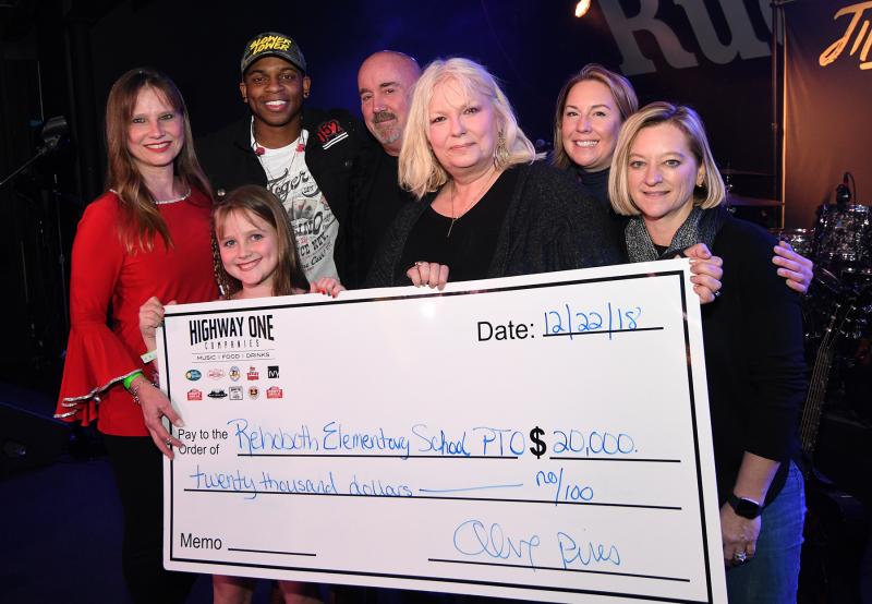 On stage with the $20,000 check (l-r) are Rehoboth elementary PTO president Deborah Nails, Natalie Nails with Jimmie Allen, John Snow, Vikki Walls, Kathleen Roberts and Meggin Holtzclaw from the Highway One Companies. DAN COOK PHOTOS