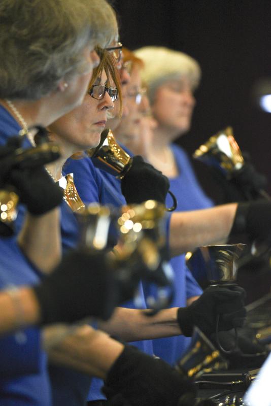 Susan Eshelman holds a handbell to pause a ring.