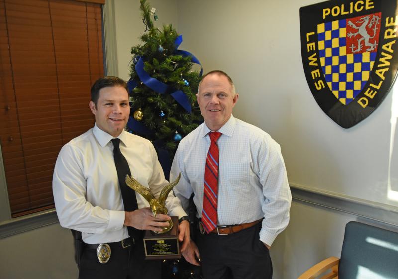 Detective Jonathan Moyer, left, holds an award he recently received for his investigative efforts throughout an embezzlement case. Police Chief Tom Spell, right, nominated Moyer for the award. NICK ROTH PHOTO
