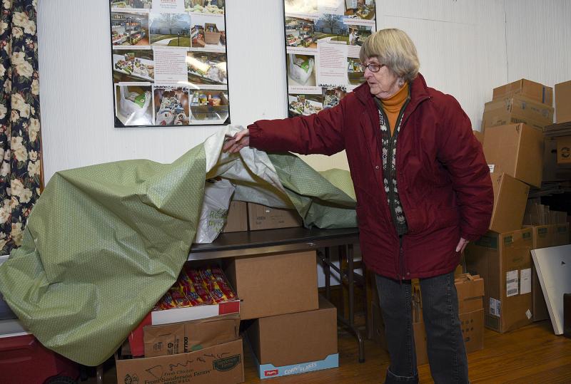 Barbara Wright shows an area under a table that is used for storage at Goshen Hall.