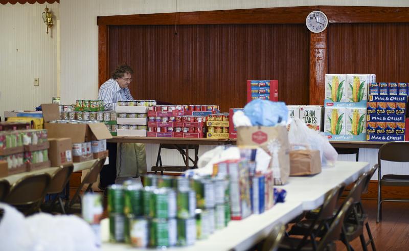 Elaine Brown works among the piles of food at Goshen Hall.