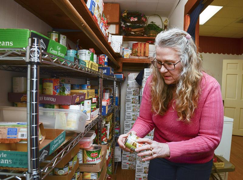 Helen Bivens checks the date on a can of apricots.