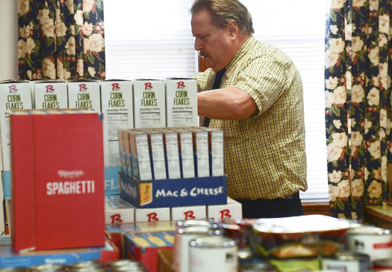 Lawrence Bivens restocks the pantry shelves with the new purchases.
