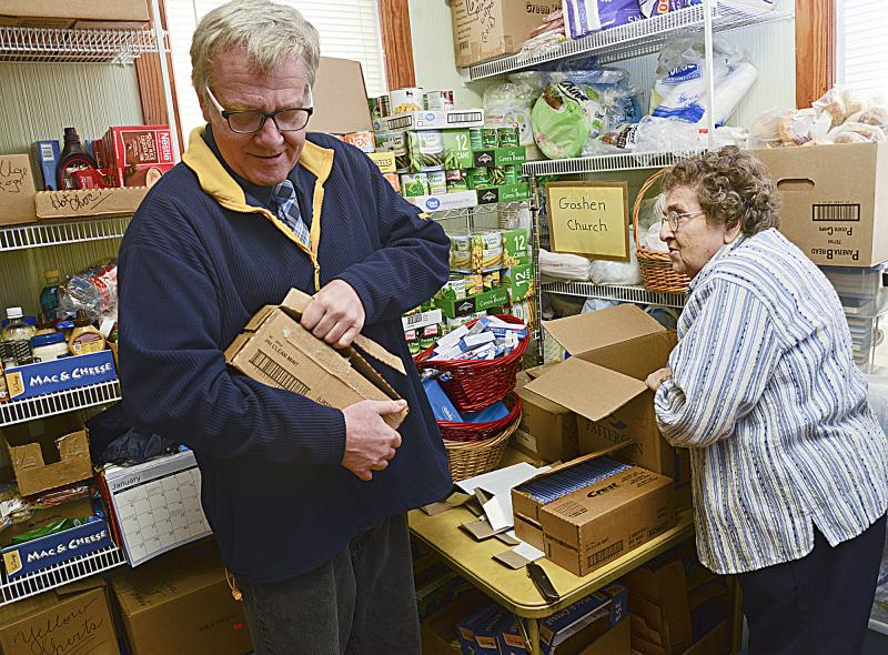 Bill Woods helps Elaine Brown get into boxes of toothpaste donated by a local dentist.