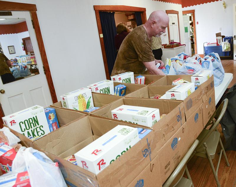 Richard Anderson helps pack boxes for families of six.