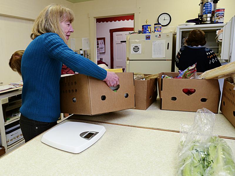 Sue Kinchy weighs a box of donated meat on a bathroom scale.