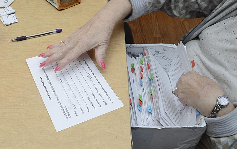 Paula Anuszewski files a patrons card after it has been signed.