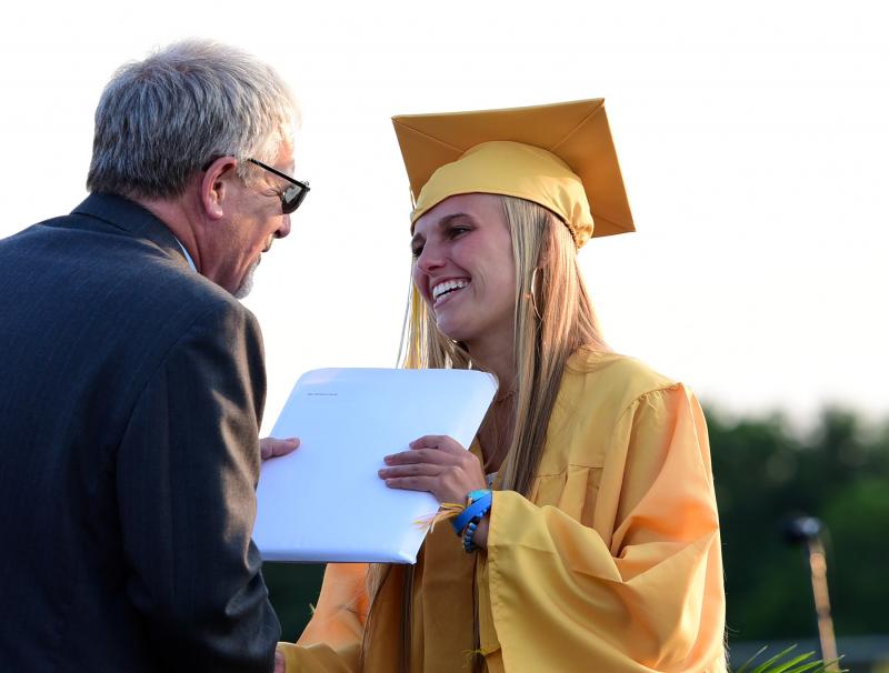 Mia Carulli receives her diploma from school board member Andy Lewis.