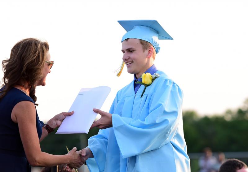 Dalton Davis receives his diploma from board president Dr. Alison Myers.