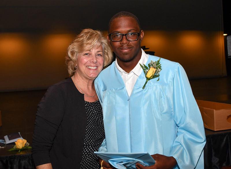 Retiring Cape teacher Sherri Cook, left, poses with one of her students, Shawn Jones, during the processional lineup.