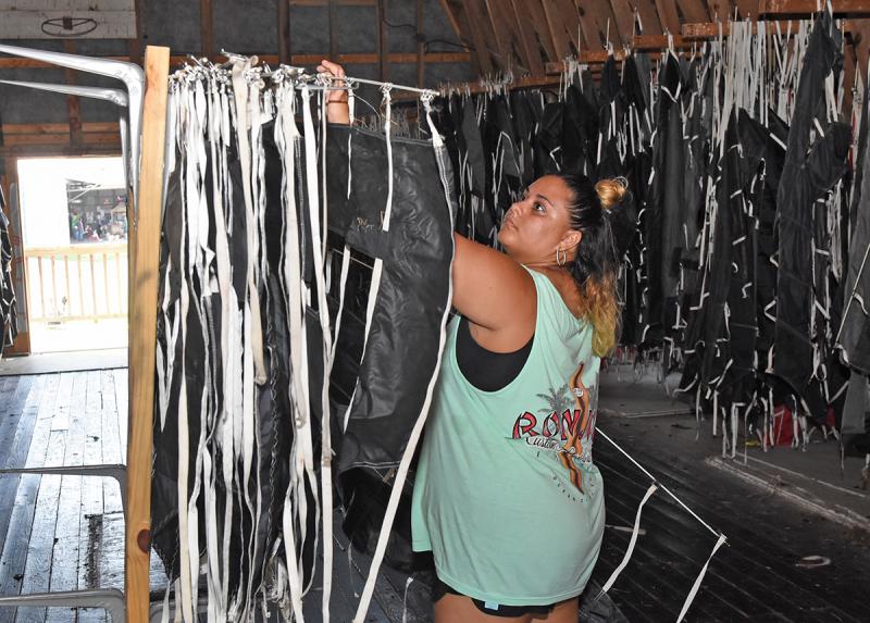 Amber Mione organizes letters in the barn before taking them out to affix to a banner.