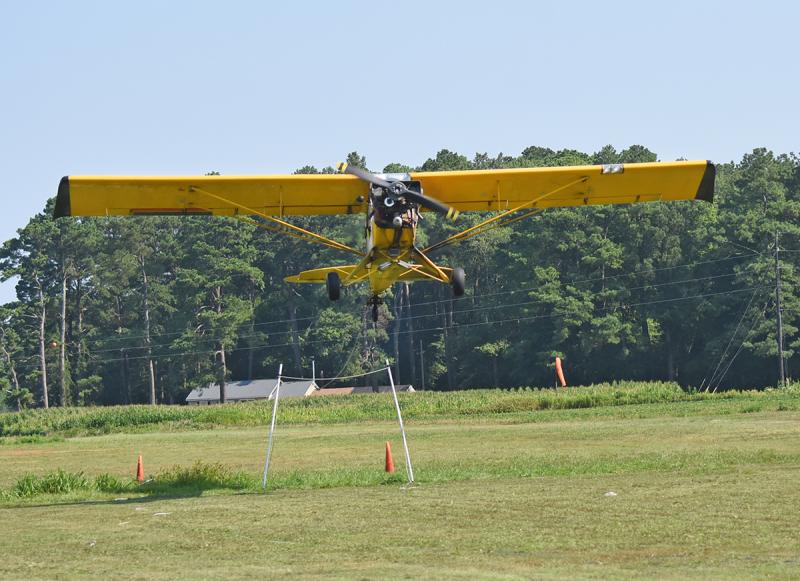 A pilot must use a grappling hook to catch a rope between two PVC pipes.