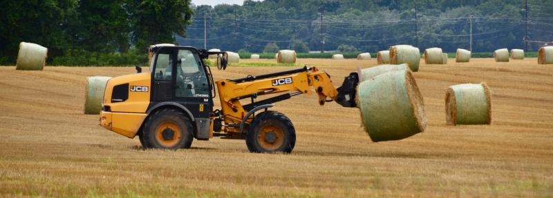 A forklift can carry two large bales of straw, which is a byproduct of the wheat harvest. Farmers use a combine to harvest wheat letting the wheat straw fall in rows on the ground, which later baled.