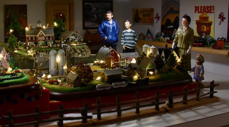 A miniature train set is displayed in a replica firehouse.