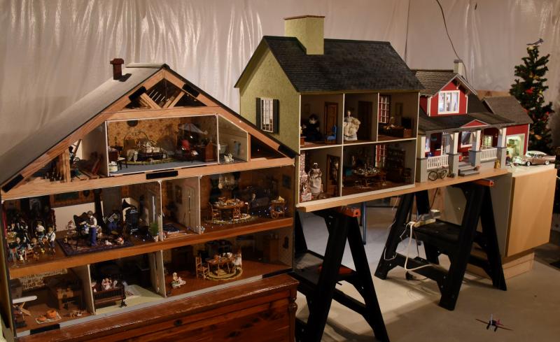 Three houses are set up on display as part of a basement full of miniatures.