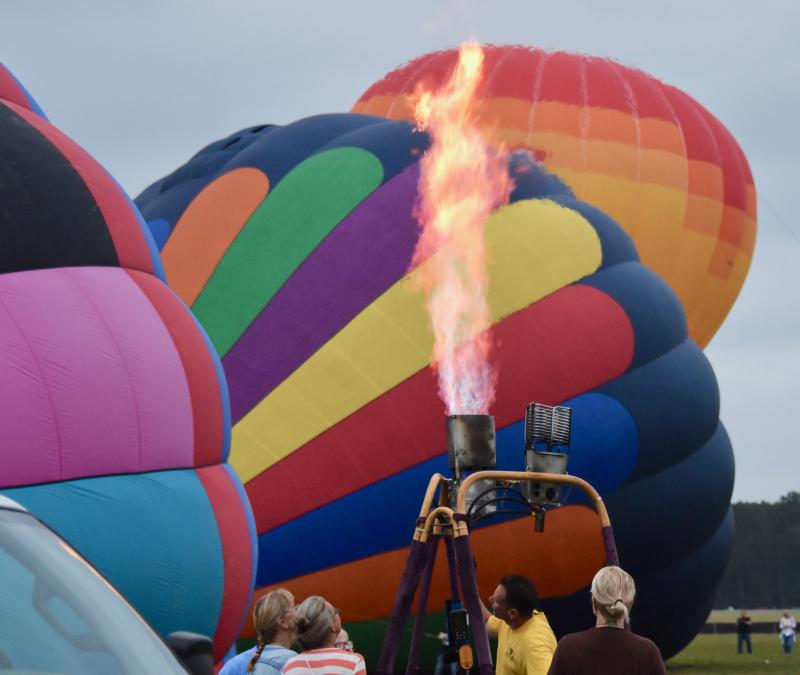A team checks its burner before attaching the balloon to the gondola.