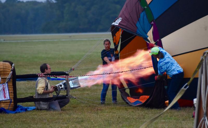 A team inflates their balloon in preparation for an early-morning takeoff.