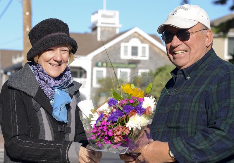 Volunteer Lisa Graff hands Ed Eaddee two flower arrangements from Floral Inspirations for Petal it Forward Day in 2018. DENY HOWETH PHOTO