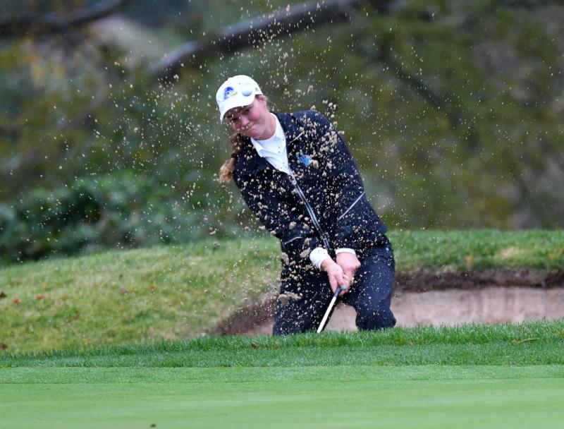 Ariane Klotz from the University of Delaware watches her shot off the beach of a sand trap.