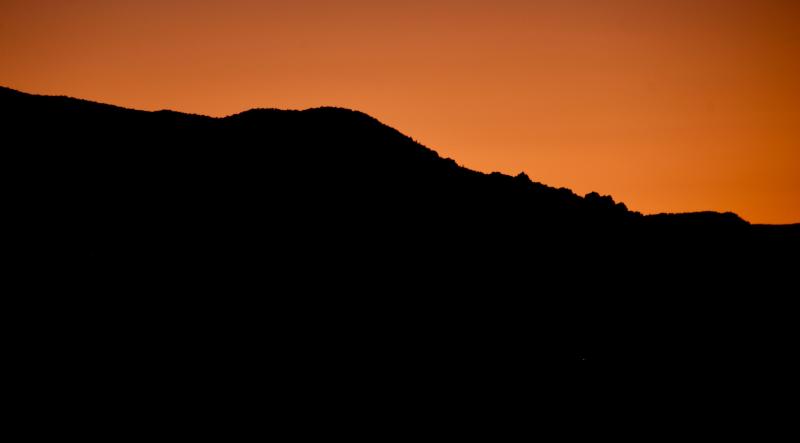 The sun sets on a mountain ridge in Torrey, one of seven small towns along the highway.