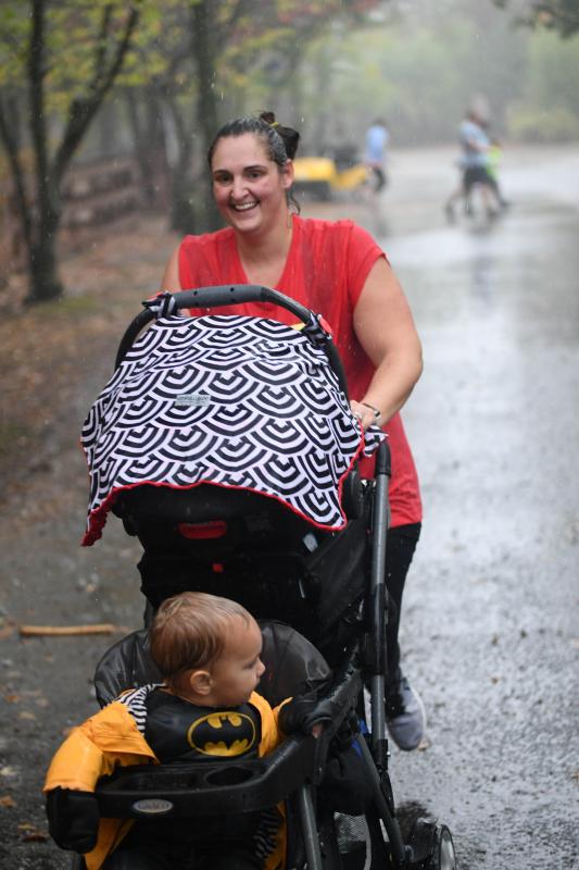 Mom and toddler are both happy to race in the rain.