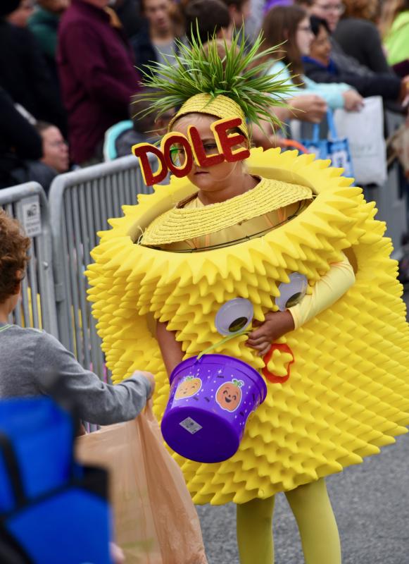 Dressed as a Dole pineapple, Minni Pettengell hands out candy along the parade route. RON MACARTHUR PHOTO
