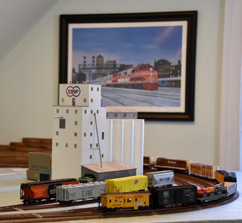 Among the buildings in the layout is a large grain elevator, a typical scene in Illinois. In the background is a prized painting of the Rock Island Rocket at the Chicago train station.