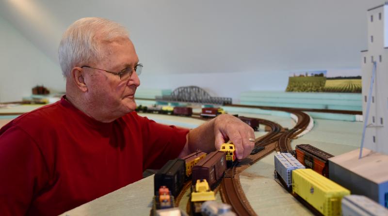 Dennis Davison places a train car on one of several tracks.