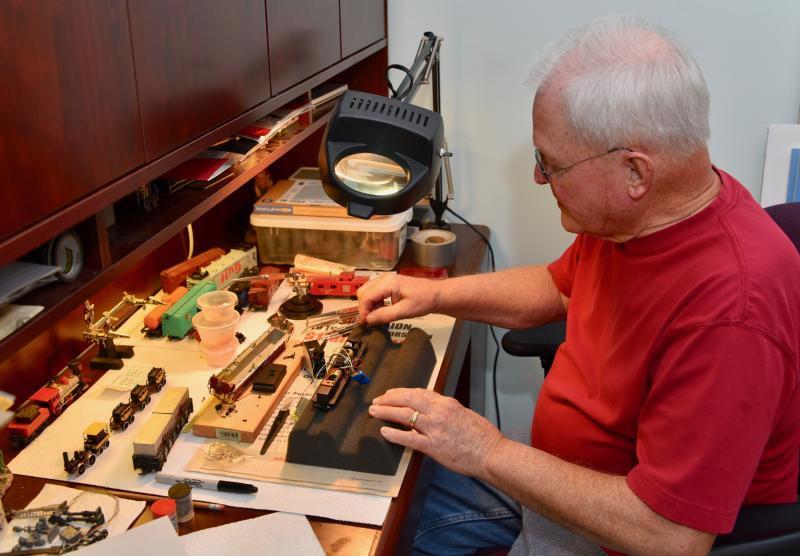 A workbench with magnifying glass is required to do the fine work required for HO-scale trains.
