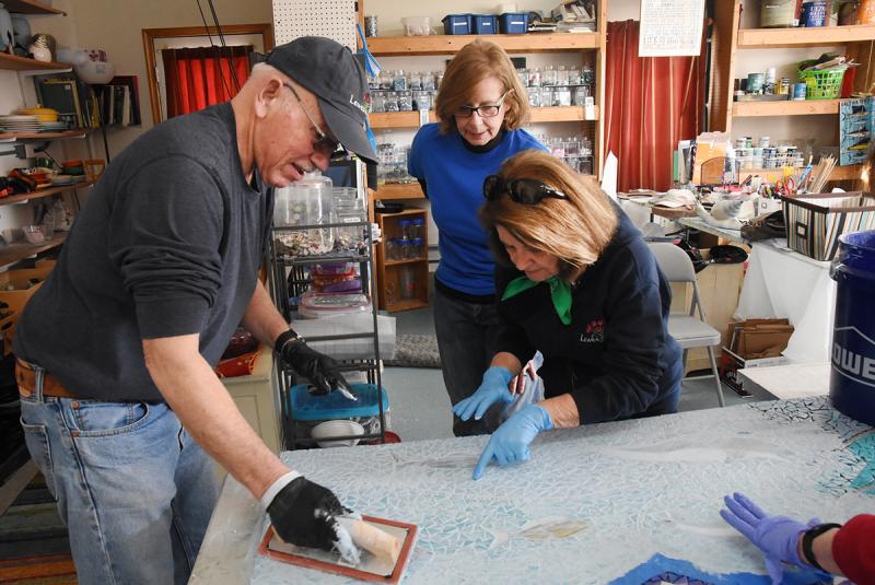 Hard at work grouting a panel of the mosaic are (l-r) Art in Bloom volunteers Bud Vai, Sue Sandmeyer and Cindy DeEmedio. NICK ROTH PHOTOS