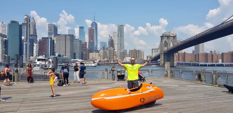 John Duffy celebrates getting back to the United States with a stop near the Brooklyn Bridge with the New York City skyline in the background.
