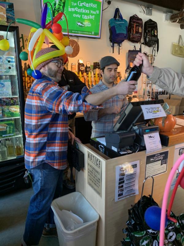 Dogfish Head brewing ambassador Bryan Selders sells a bottle of Mr. Chuckles Feb. 29. ROB WATERS PHOTO