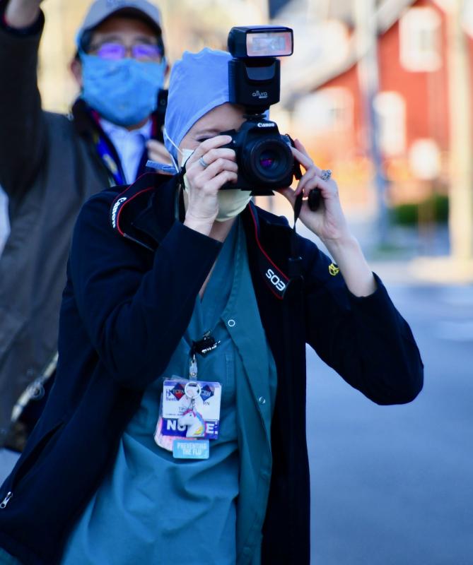 Beebe nurse Tiffany Travis photographs the procession of first responders vehicles. RON MACARTHUR PHOTO