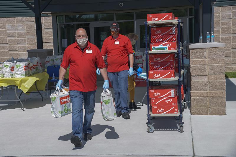 Joe Abrignani, Weis produce manager, carries bags to a car.