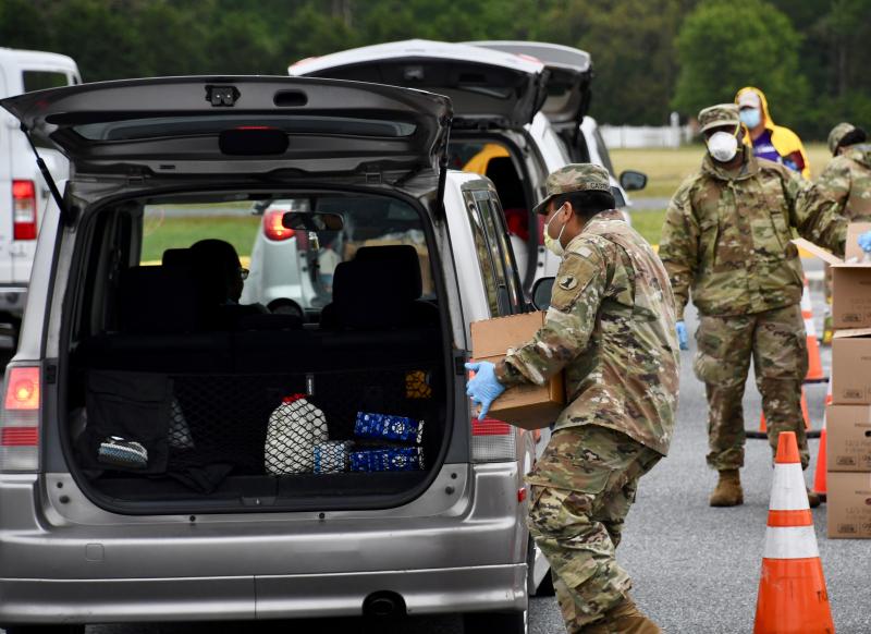 Vehicles drive through the lines with rear doors and trunks open to avoid personal contact.
