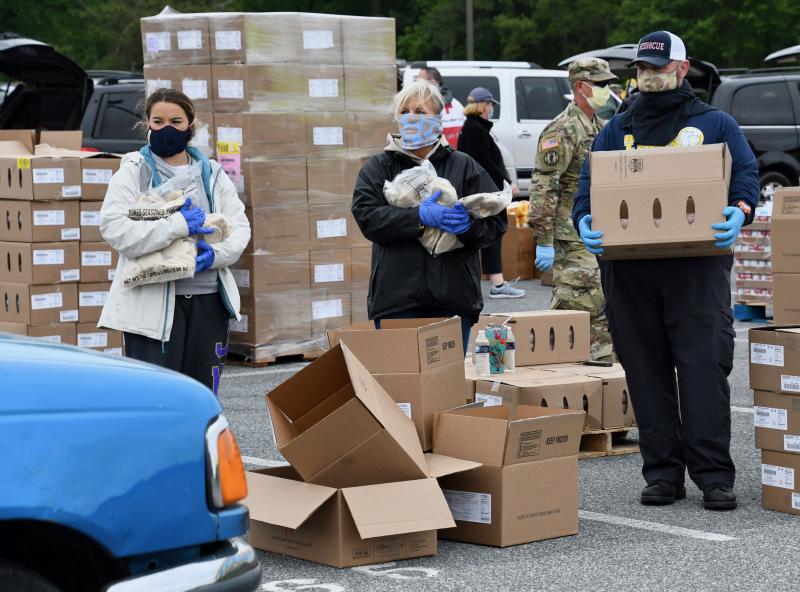 Volunteers are ready to put staples – including frozen chicken – in an approaching vehicle.