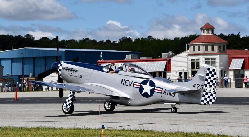 Rosalie, a P-51 Mustang, taxis to the runway in front of the Delaware Coastal Airport terminal.
