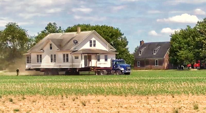 This still photo, extracted from a video, shows the 1912 Sussex farmhouse being moved across a cornfield to its new location on Atlanta Road. In the background is the 1727 Cannon-Maston House. MARK CHURA IMAGE