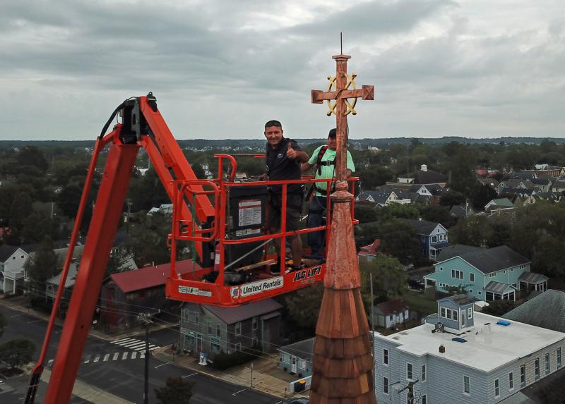 Andrew Lewandowski, left, and Gerardo Hernandez of Bayside Exteriors attach the new cross to the steeple of St. Peter’s Church in downtown Lewes. NICK ROTH PHOTOS